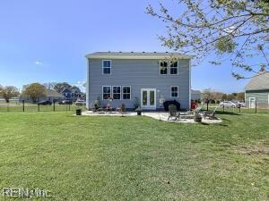 back of property with a yard, a patio, and fence