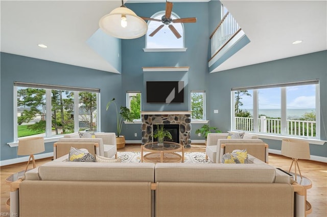 89 Sandy Bay Dr, Poquoson, VA 23662 - living room featuring a fireplace, a towering ceiling, baseboards, and ceiling fan