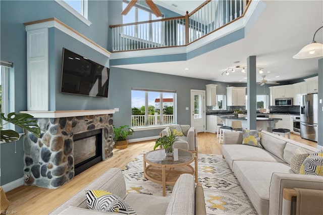 89 Sandy Bay Dr, Poquoson, VA 23662 - living room with a ceiling fan, a towering ceiling, a fireplace, and light wood-style floors
