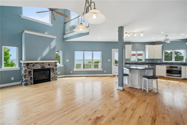 89 Sandy Bay Dr, Poquoson, VA 23662 - living area with light wood-type flooring, baseboards, a stone fireplace, and ceiling fan