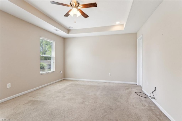 carpeted spare room featuring visible vents, baseboards, recessed lighting, ceiling fan, and a raised ceiling