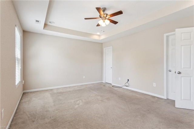 carpeted empty room featuring baseboards, a ceiling fan, visible vents, and a wealth of natural light