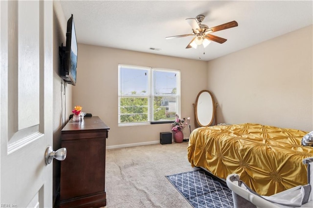 carpeted bedroom with visible vents, baseboards, and ceiling fan