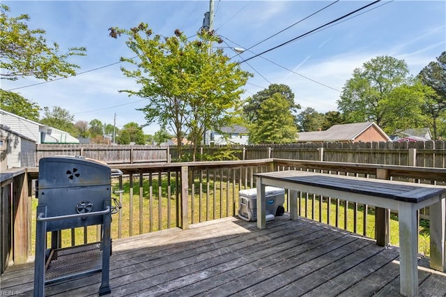 wooden deck with a lawn, a fenced backyard, and a grill