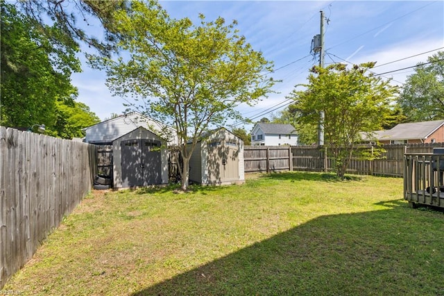 view of yard with a fenced backyard, an outbuilding, and a storage shed