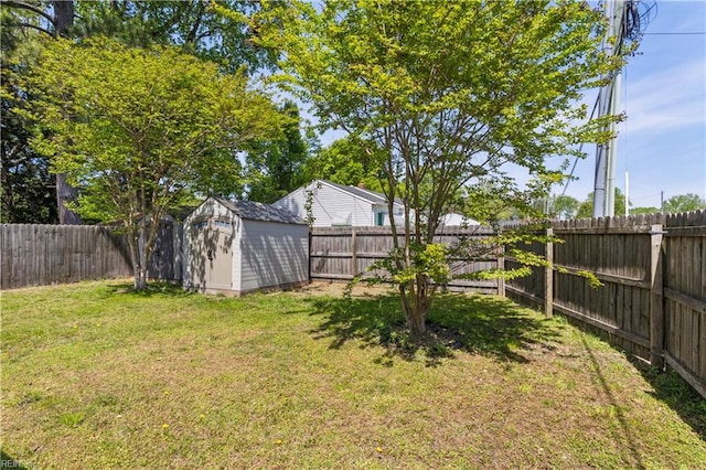 view of yard with a fenced backyard, an outbuilding, and a storage shed