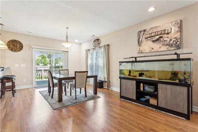 dining area with baseboards, wood finished floors, and recessed lighting