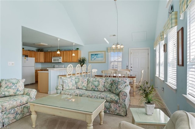 206 E Palmetto St, Kill Devil Hills, NC 27948 - living area featuring high vaulted ceiling, a chandelier, and a healthy amount of sunlight