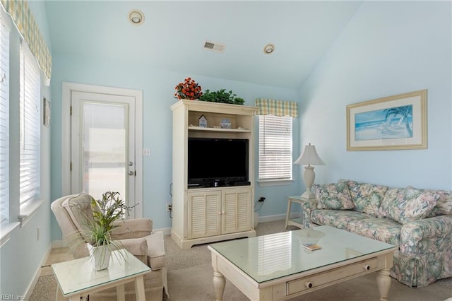 206 E Palmetto St, Kill Devil Hills, NC 27948 - living area featuring plenty of natural light, carpet flooring, baseboards, and vaulted ceiling