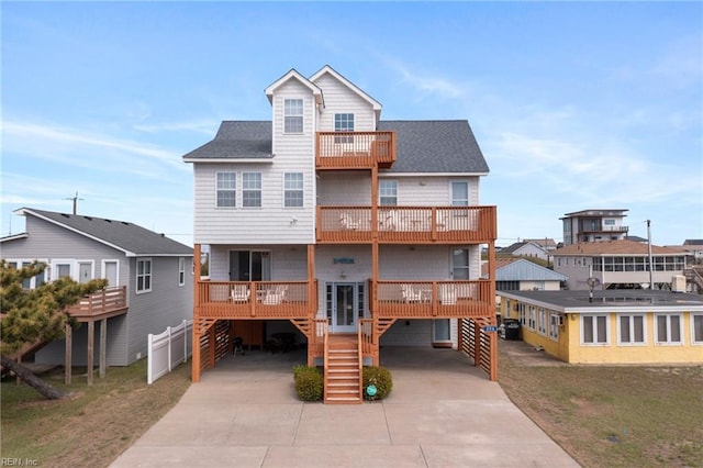 206 E Palmetto St, Kill Devil Hills, NC 27948 - rear view of property with a residential view, stairway, a carport, a shingled roof, and driveway
