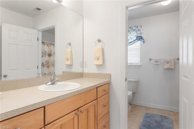 206 E Palmetto St, Kill Devil Hills, NC 27948 - full bathroom featuring vanity, baseboards, tile patterned flooring, toilet, and visible vents
