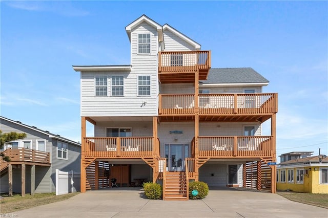 206 E Palmetto St, Kill Devil Hills, NC 27948 - raised beach house with a carport, stairs, and concrete driveway