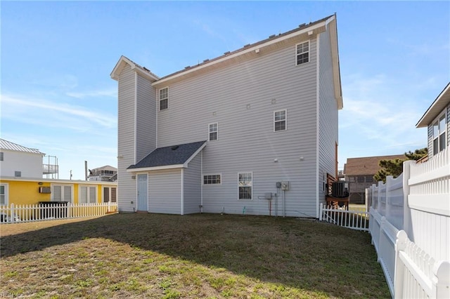 206 E Palmetto St, Kill Devil Hills, NC 27948 - back of house featuring a yard, central AC unit, and a fenced backyard
