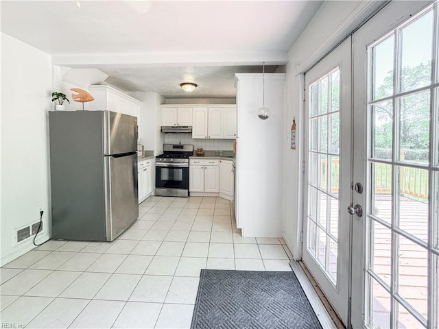 kitchen featuring white cabinets, under cabinet range hood, stainless steel appliances, visible vents, and light tile patterned flooring