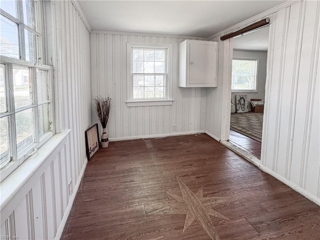 unfurnished room with baseboards, dark wood-style flooring, and crown molding