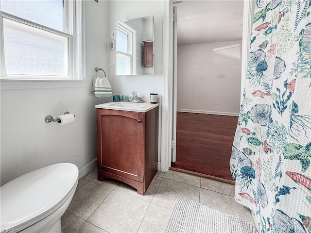 bathroom featuring vanity, curtained shower, baseboards, toilet, and tile patterned flooring