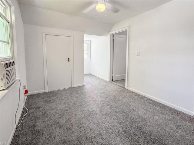 spare room featuring ceiling fan, vaulted ceiling, carpet flooring, and baseboards