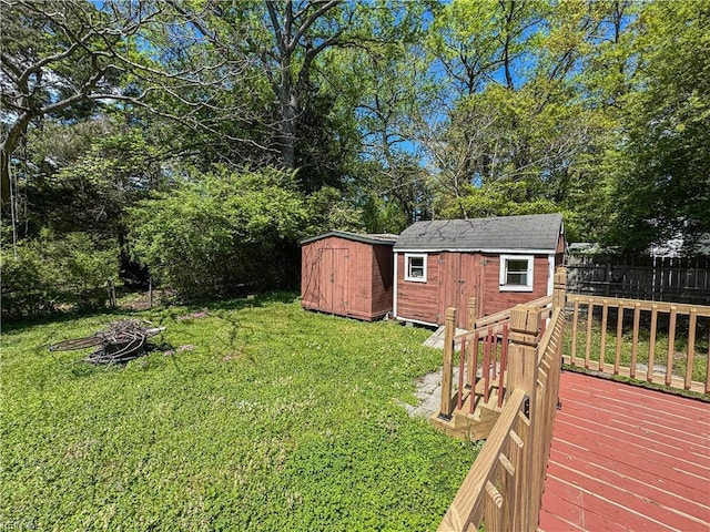 view of yard with fence, an outbuilding, a shed, and an outdoor fire pit