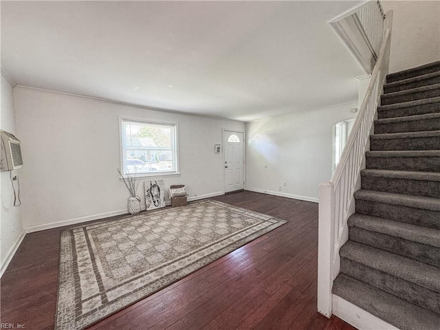 entryway featuring stairway, crown molding, baseboards, a wall mounted AC, and hardwood / wood-style flooring