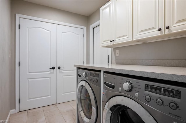laundry room with washing machine and dryer, baseboards, cabinet space, and light tile patterned flooring
