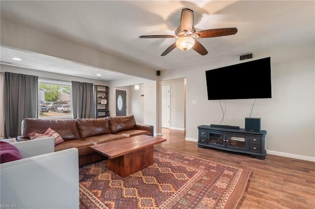 living room featuring wood finished floors, a ceiling fan, and baseboards