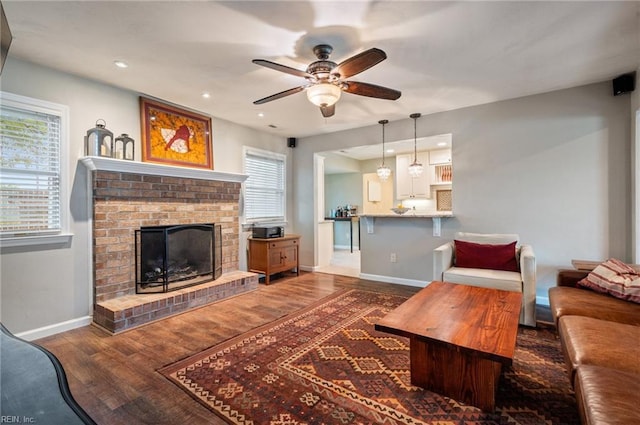 living room featuring wood finished floors, a wealth of natural light, a ceiling fan, and baseboards