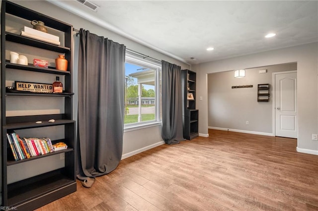 unfurnished room featuring baseboards, wood finished floors, visible vents, and recessed lighting