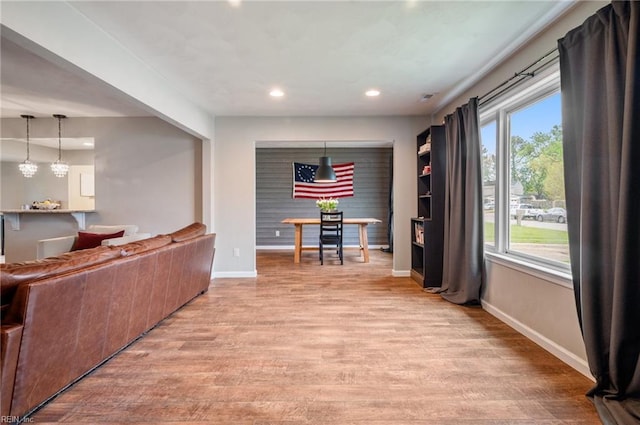 living area featuring light wood-style flooring, baseboards, and recessed lighting