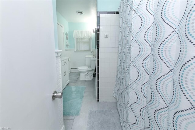 full bath featuring curtained shower, tile patterned flooring, visible vents, toilet, and a baseboard heating unit