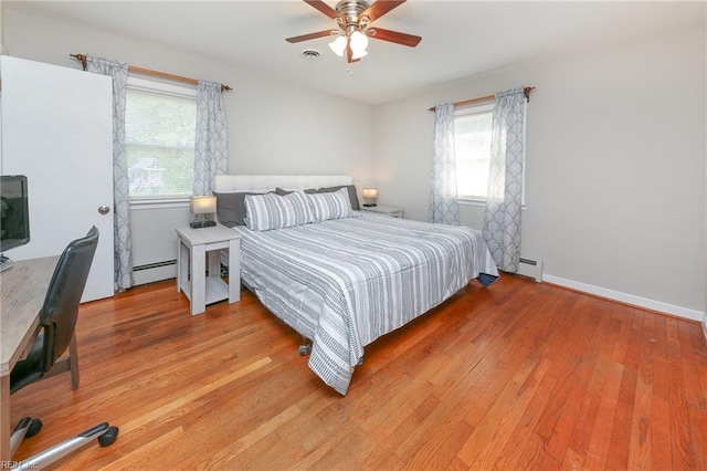 bedroom with light wood finished floors, a ceiling fan, visible vents, and a baseboard radiator