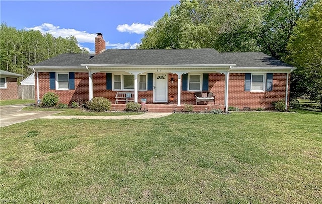 ranch-style home featuring a porch, a chimney, brick siding, and a front yard