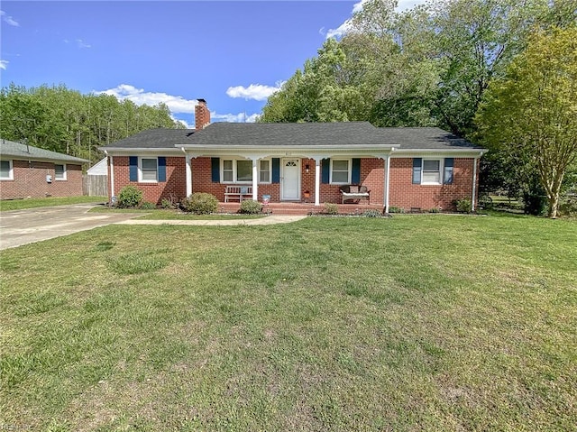 ranch-style home with a chimney, brick siding, a front yard, and covered porch