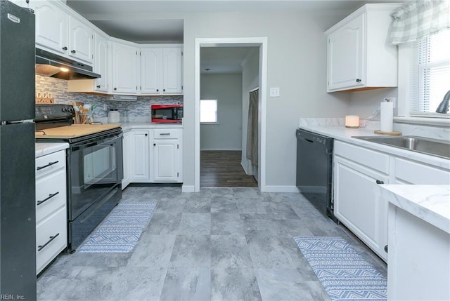 kitchen with black appliances, a wealth of natural light, under cabinet range hood, and white cabinets