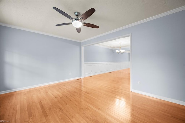 unfurnished room featuring a wainscoted wall, wood finished floors, a textured ceiling, and ceiling fan with notable chandelier