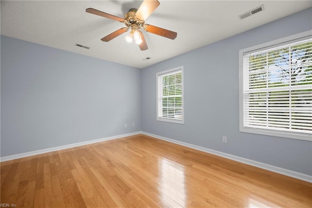 empty room with baseboards, light wood-style flooring, and visible vents