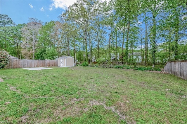 view of yard featuring a storage shed, a fenced backyard, and an outdoor structure