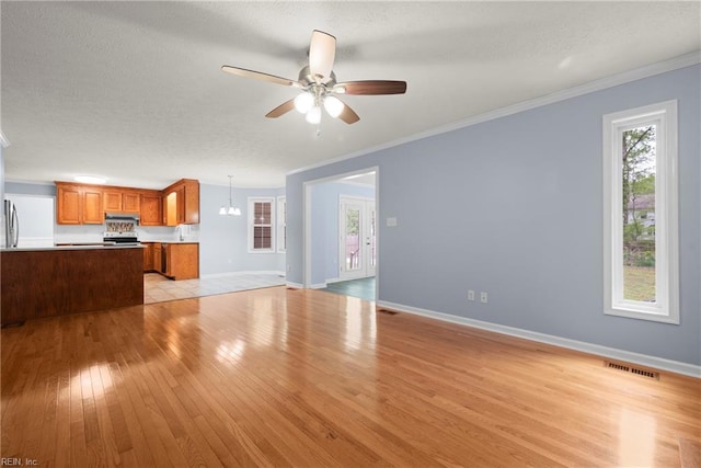unfurnished living room featuring light wood finished floors, visible vents, crown molding, and ceiling fan with notable chandelier