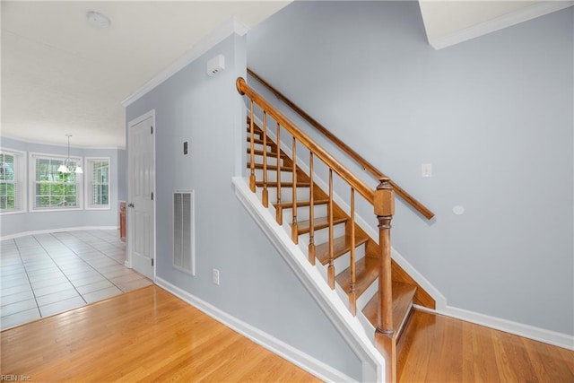 stairway featuring baseboards, visible vents, and ornamental molding