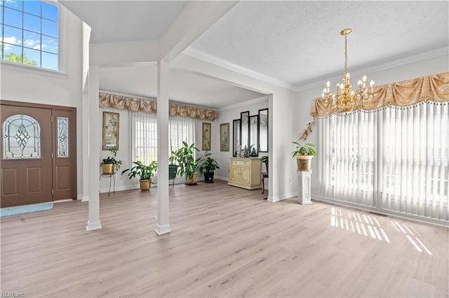 entryway featuring a notable chandelier, light wood-style floors, and a healthy amount of sunlight