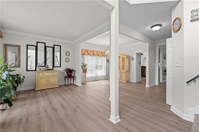 interior space with light wood-style floors, crown molding, and baseboards