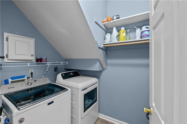 laundry room featuring washer and clothes dryer, laundry area, and a textured ceiling