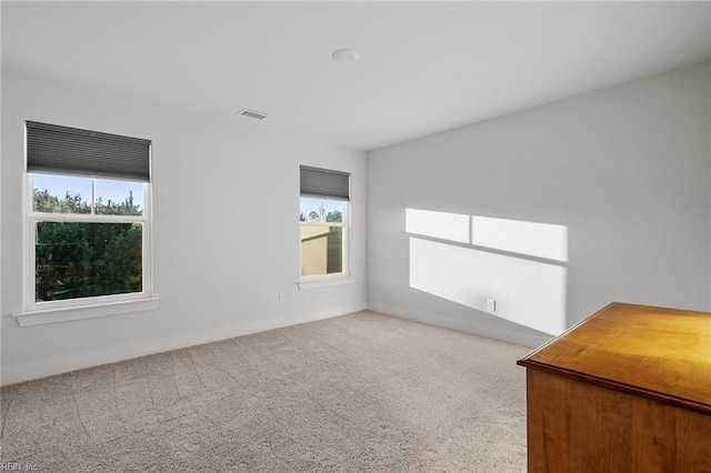 spare room with baseboards, visible vents, and carpet flooring