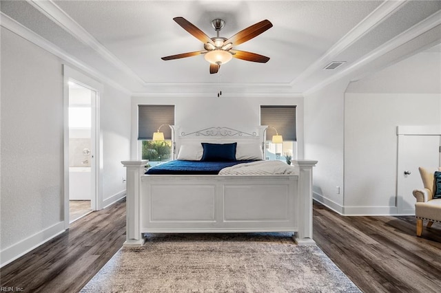 bedroom featuring a tray ceiling, wood finished floors, visible vents, and ornamental molding