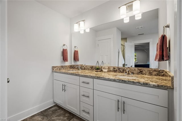 full bath with double vanity, visible vents, baseboards, and a sink