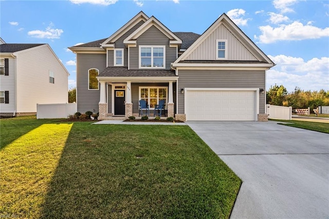 craftsman-style house with a front lawn, covered porch, concrete driveway, fence, and board and batten siding