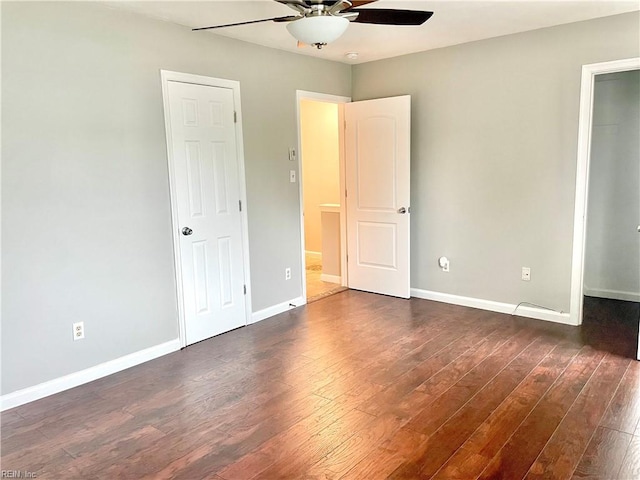 unfurnished bedroom featuring dark wood-type flooring, a ceiling fan, and baseboards