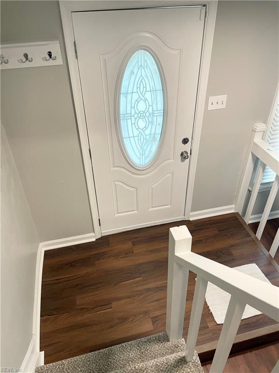 foyer with stairs, baseboards, and dark wood-type flooring