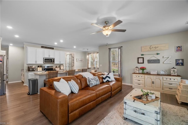 living area featuring recessed lighting, wood finished floors, a ceiling fan, and baseboards