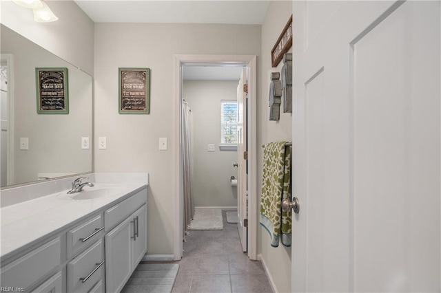 bathroom featuring baseboards, tile patterned floors, and vanity
