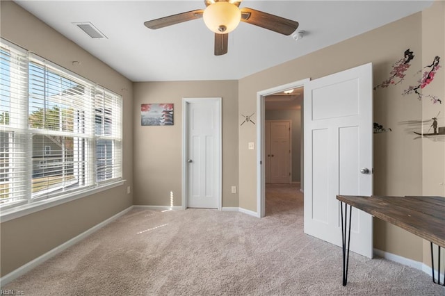 unfurnished bedroom featuring baseboards, visible vents, carpet floors, and multiple windows